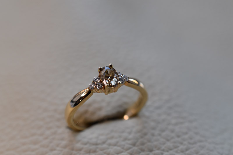 Guldring i 14kt guld med 0,53ct oval champagnefarvet diamant og i alt 0,12ct Top Wesselton VS brillianter på siden.