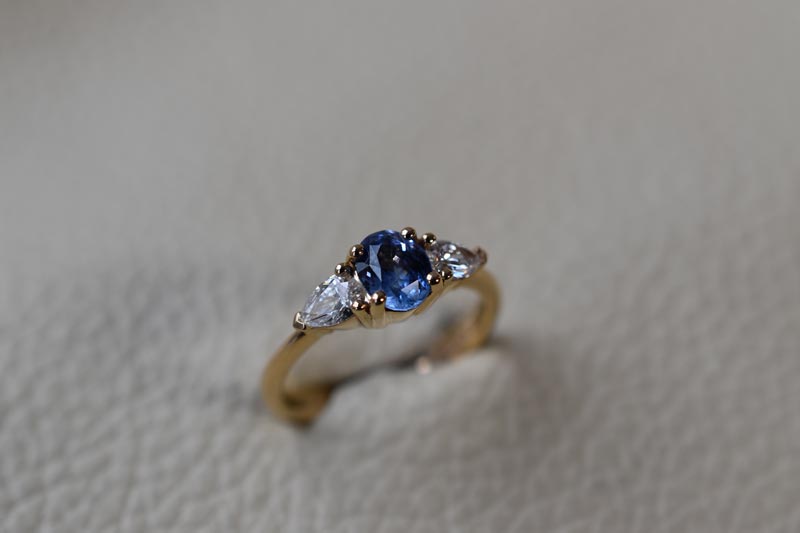 Trestensring i 18kt guld med 1,3ct oval blå safir og dråbeformede diamanter på i alt 0,42ct Top Wesselton VS.