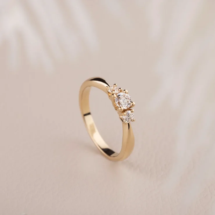 Trinity ring – 0,25ct TW VS brilliant centersten, 2 mindre hvide brillianter i alt 0,20ct TW VS, 14kt gult guld